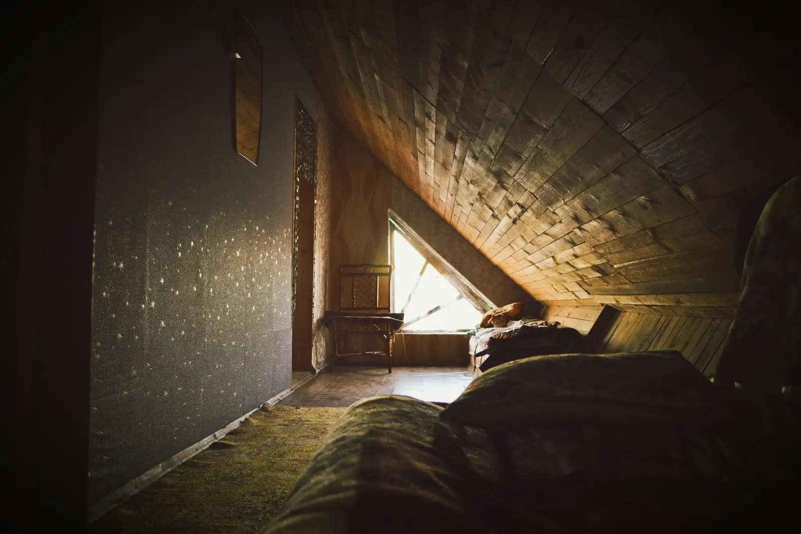 A dim attic with light coming through a gap