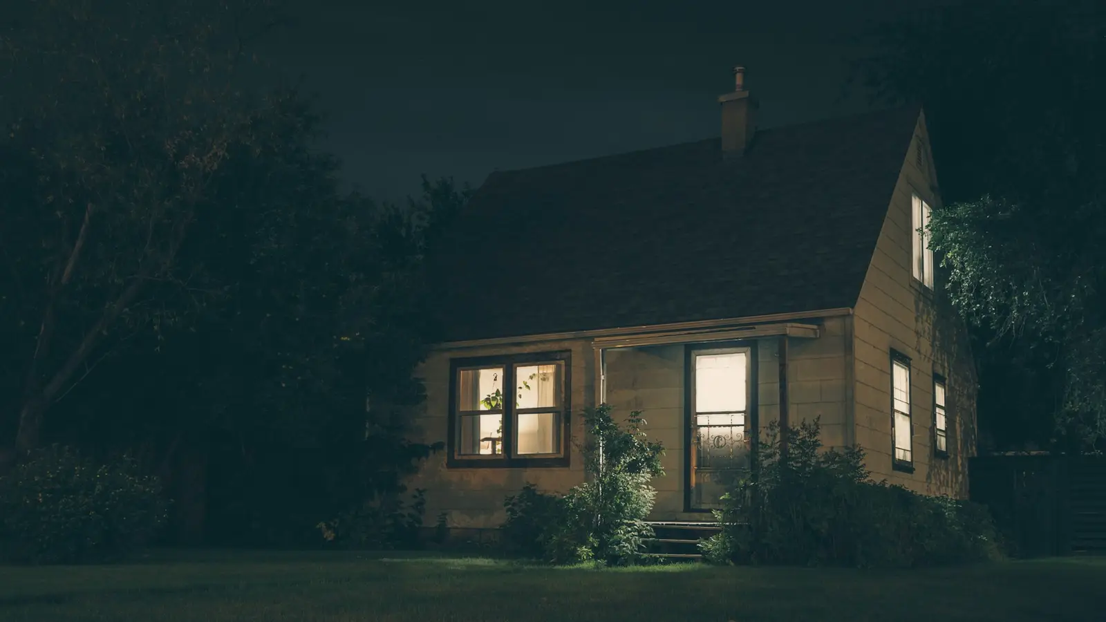 A house at night with its windows lit